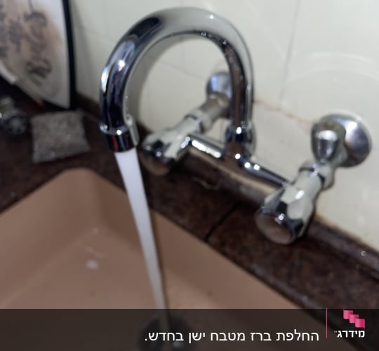 ברז מים זורם בכיור מטבח